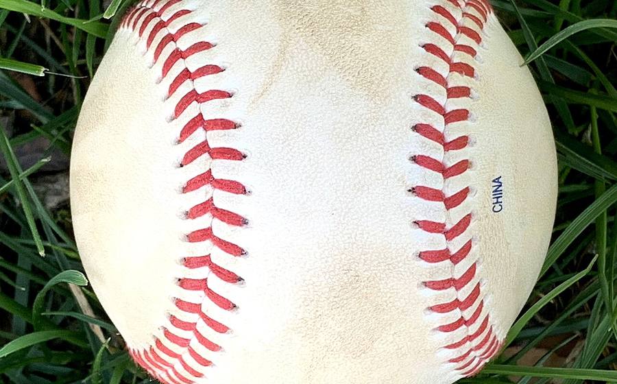 Red-stitched leather baseball seams (representative photo)